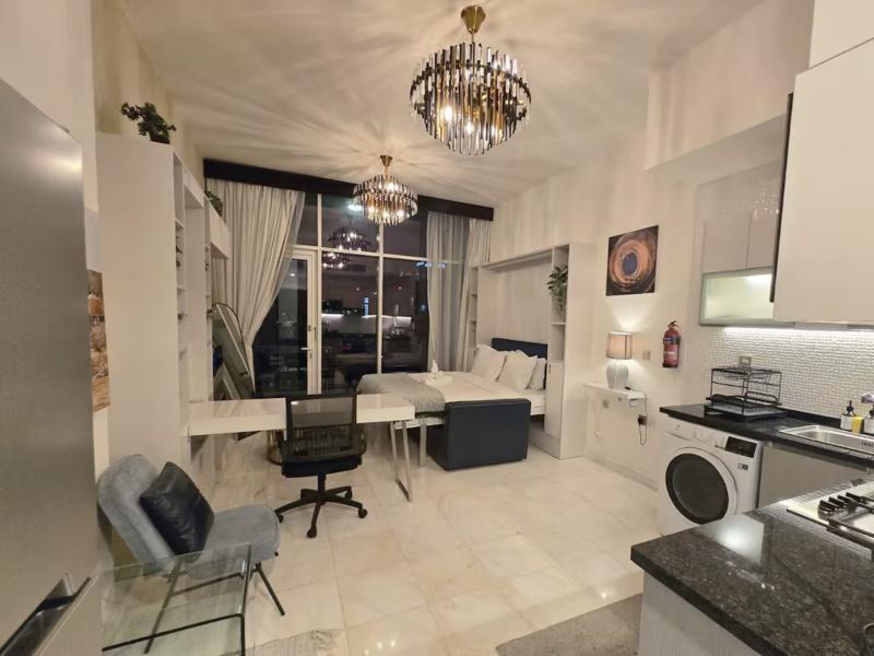 The studio at night with chandeliers, desk and kitchen