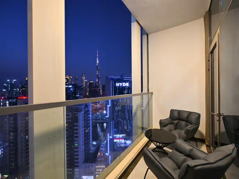 Balcony with two armchairs and the Burj Khalifa lit up at night